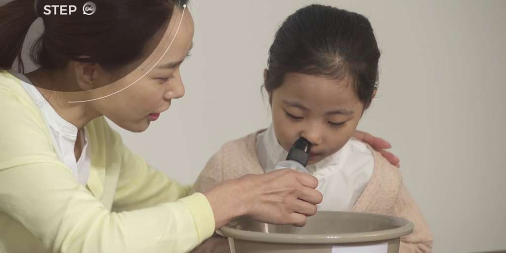 엄마가 아이의 코 세척을 도와주는 모습
