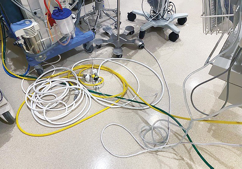 Cluttered hospital room floor with medical equipment and cables